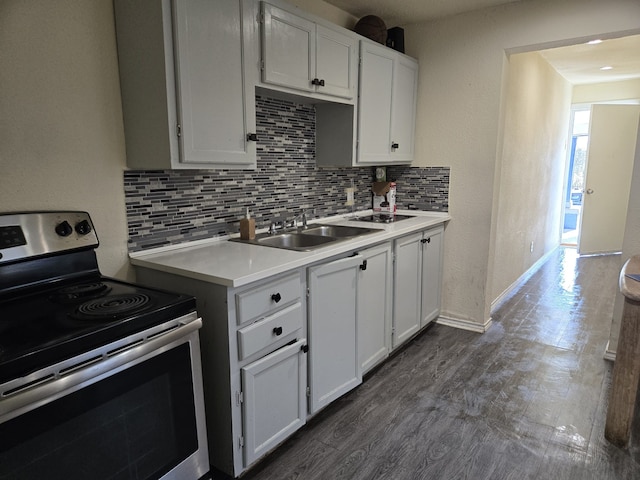 kitchen featuring stainless steel electric stove, dark hardwood / wood-style floors, sink, white cabinets, and decorative backsplash