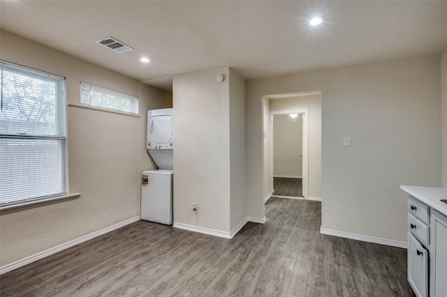 washroom with light hardwood / wood-style flooring and stacked washer / dryer