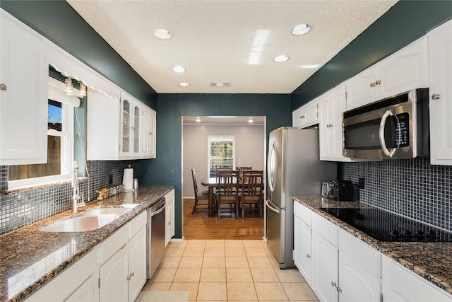 kitchen featuring stainless steel appliances, sink, light tile patterned floors, and white cabinets