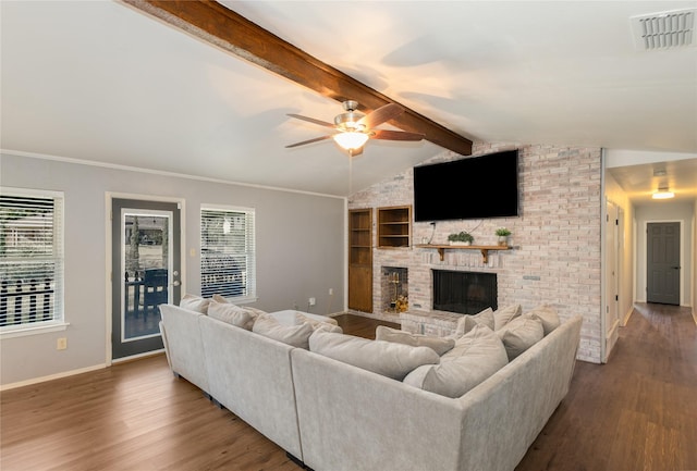 living room with a fireplace, lofted ceiling with beams, dark hardwood / wood-style flooring, ornamental molding, and ceiling fan