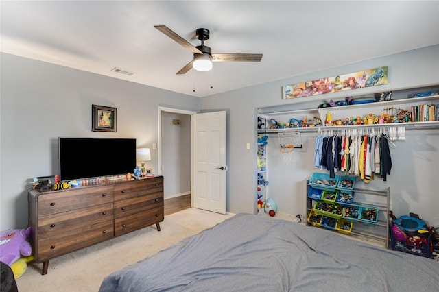 carpeted bedroom featuring ceiling fan and a closet