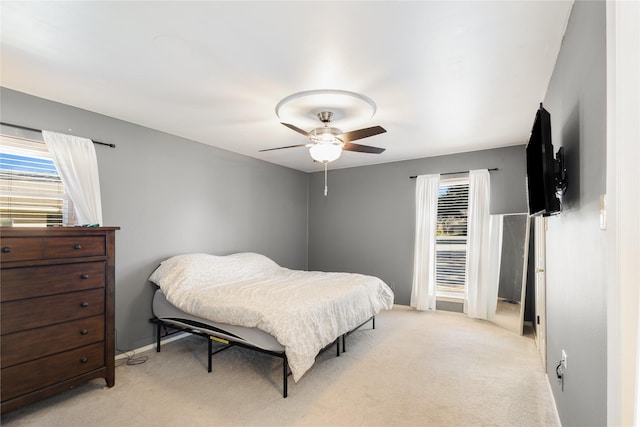 bedroom with ceiling fan and light carpet