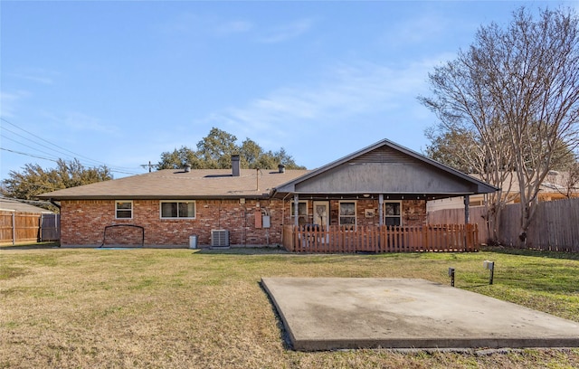 back of property with cooling unit, a lawn, and a patio