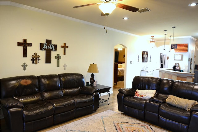 living room with crown molding, light hardwood / wood-style floors, and ceiling fan