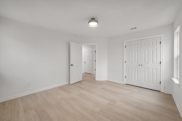 unfurnished bedroom featuring light hardwood / wood-style floors and a closet