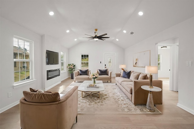 living room featuring ceiling fan, lofted ceiling, and light hardwood / wood-style flooring