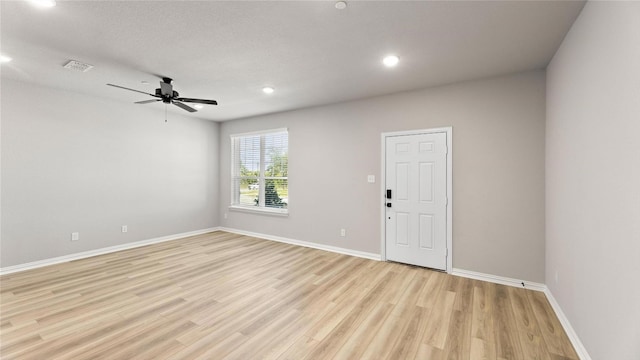 spare room with a textured ceiling, light hardwood / wood-style flooring, and ceiling fan