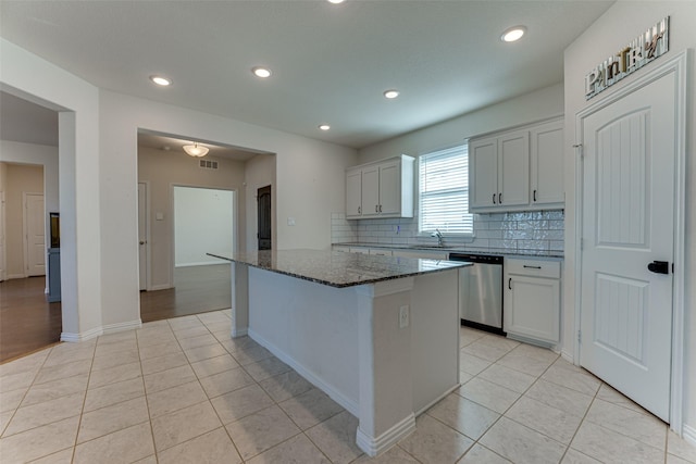 kitchen with white cabinetry, dishwasher, and a kitchen island