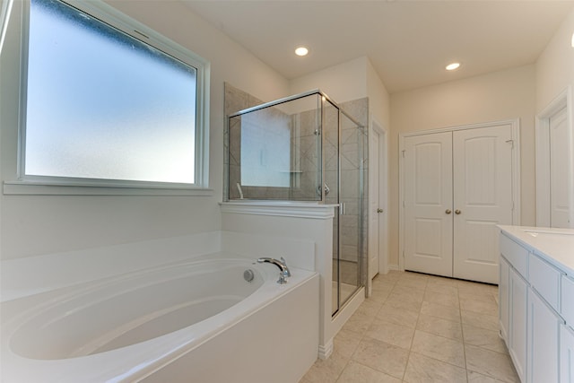 bathroom featuring independent shower and bath, vanity, and tile patterned flooring