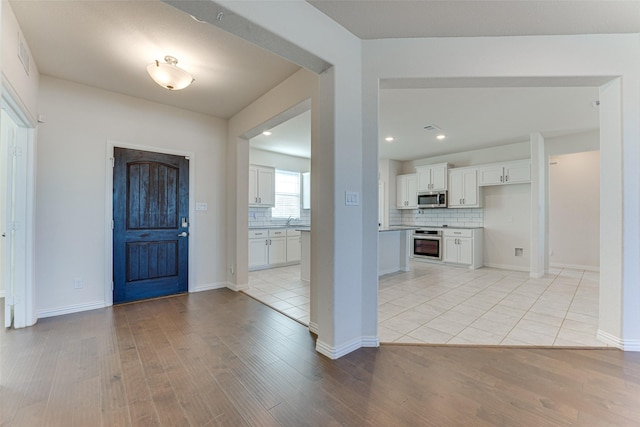 foyer entrance with sink and light hardwood / wood-style flooring