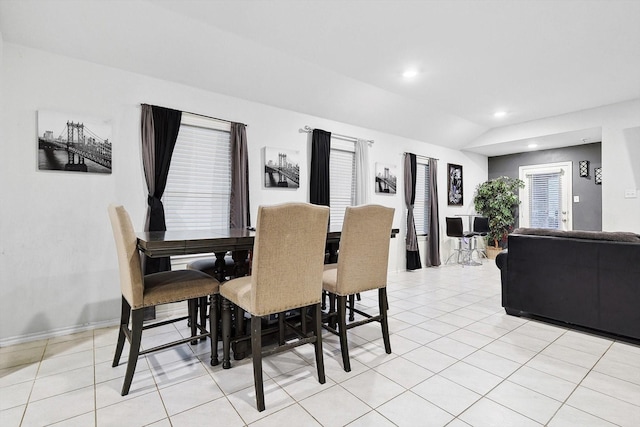 dining room with light tile patterned floors and vaulted ceiling