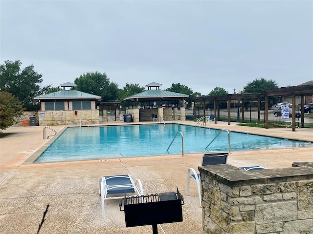 view of pool featuring a gazebo, a pergola, a bar, and a patio area