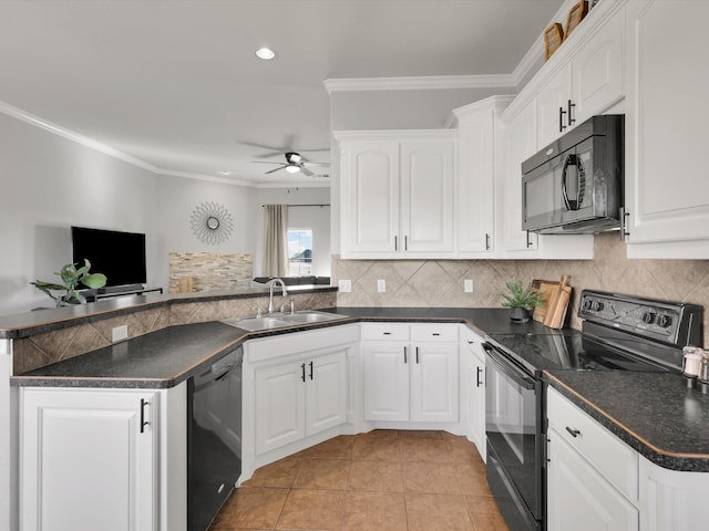 kitchen with dark countertops, black appliances, white cabinets, and a sink