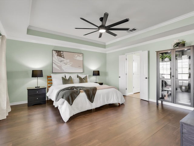 bedroom featuring ornamental molding, dark wood-type flooring, visible vents, and baseboards