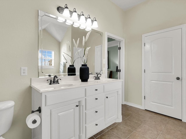 full bath with double vanity, toilet, a sink, and tile patterned floors