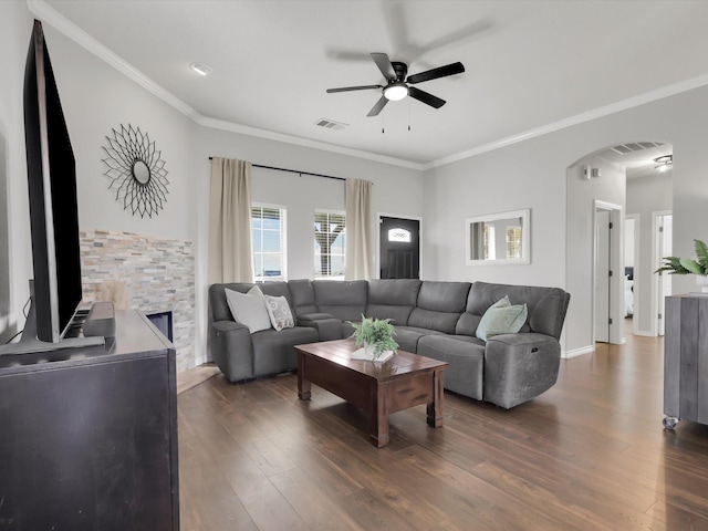 living room with visible vents, arched walkways, a ceiling fan, ornamental molding, and dark wood-type flooring