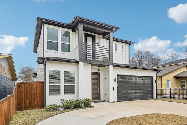 contemporary home with a balcony, board and batten siding, concrete driveway, and fence