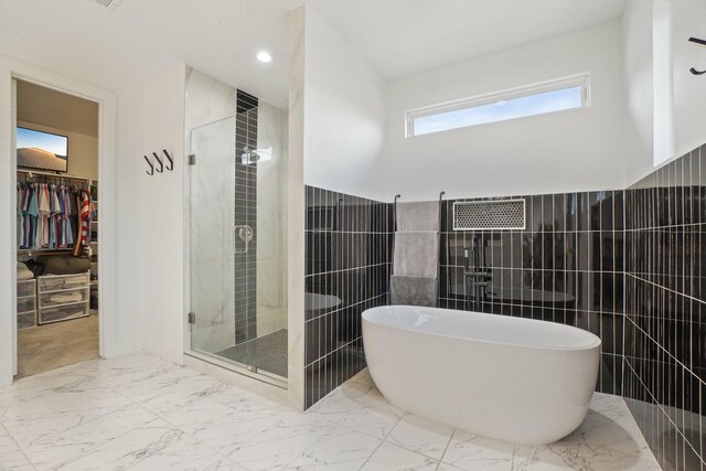 3426 Borger St, Dallas, TX 75212 - full bath with a spacious closet, tile walls, marble finish floors, a freestanding bath, and a shower stall