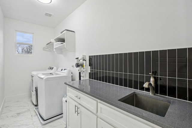 3426 Borger St, Dallas, TX 75212 - laundry area with cabinet space, washing machine and clothes dryer, light marble finish floors, and baseboards