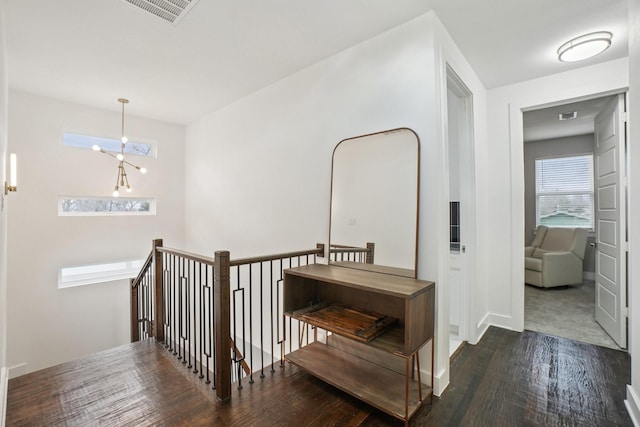 corridor featuring wood finished floors, an upstairs landing, and visible vents