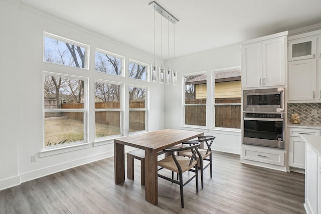 dining space featuring a wealth of natural light and dark hardwood / wood-style flooring