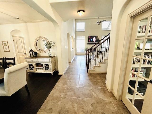 tiled foyer entrance featuring a high ceiling and ceiling fan