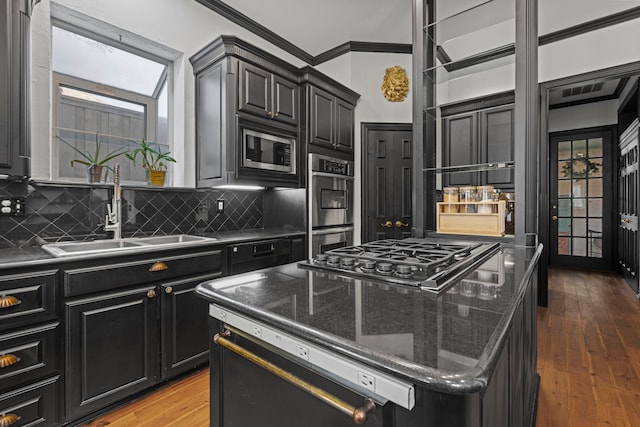 kitchen with a kitchen island, sink, dark hardwood / wood-style flooring, decorative backsplash, and stainless steel appliances