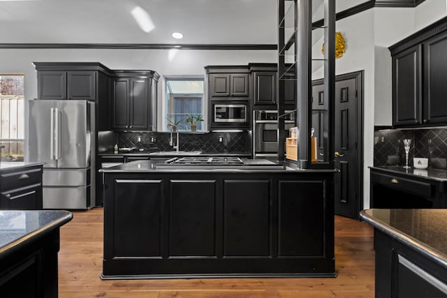 kitchen featuring sink, hardwood / wood-style flooring, stainless steel appliances, and backsplash