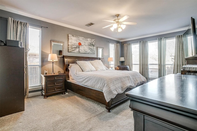 carpeted bedroom with ornamental molding and ceiling fan