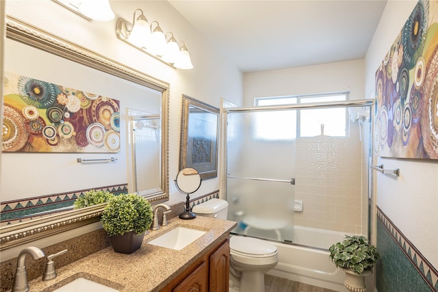 full bathroom with vanity, toilet, combined bath / shower with glass door, and wood-type flooring