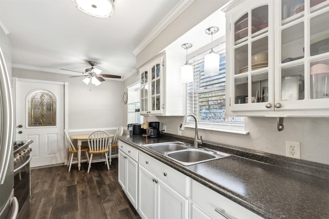 kitchen with pendant lighting, sink, crown molding, and white cabinets