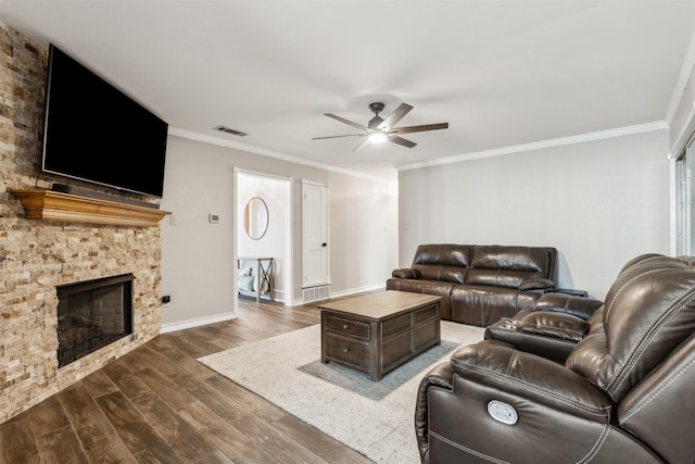 living room with dark wood-style floors, a fireplace, visible vents, and ornamental molding