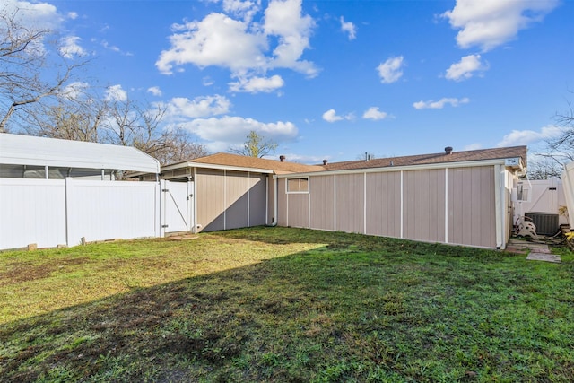 view of yard featuring a gate, central AC unit, and fence