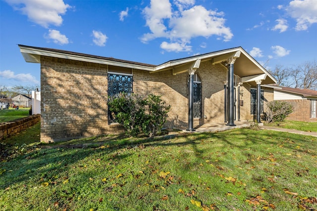 view of property exterior with a yard and brick siding