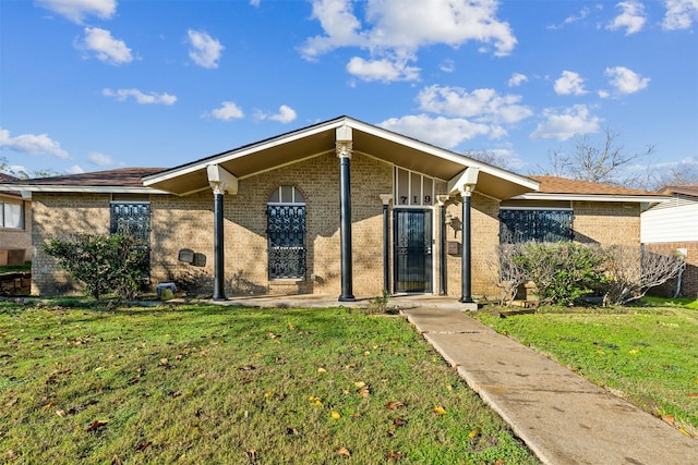 mid-century home featuring brick siding and a front lawn