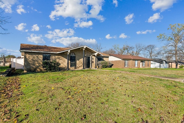 view of front of property featuring brick siding and a front yard