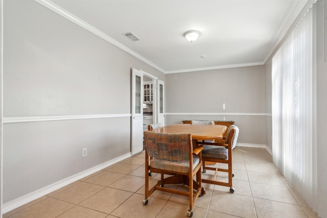 dining room with ornamental molding, visible vents, baseboards, and light tile patterned floors