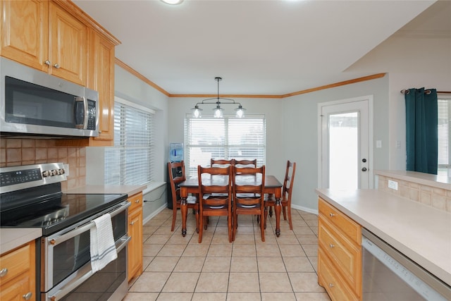 kitchen featuring backsplash, decorative light fixtures, light tile patterned floors, and appliances with stainless steel finishes