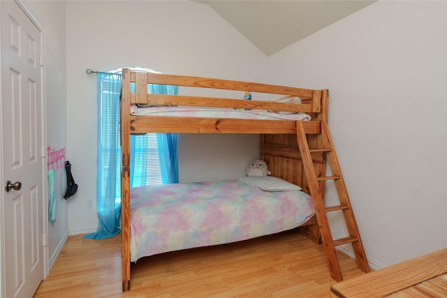 bedroom with lofted ceiling and light hardwood / wood-style flooring