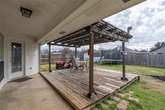 wooden terrace featuring a trampoline, a pergola, and a lawn