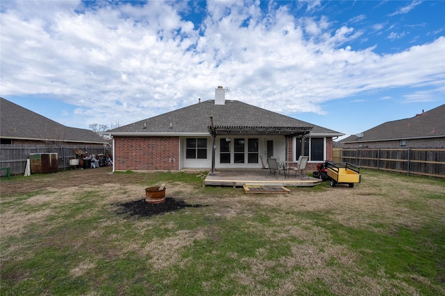 rear view of house with a pergola, a lawn, and a deck