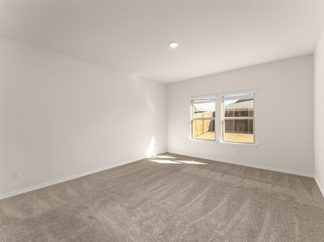carpeted spare room with baseboards
