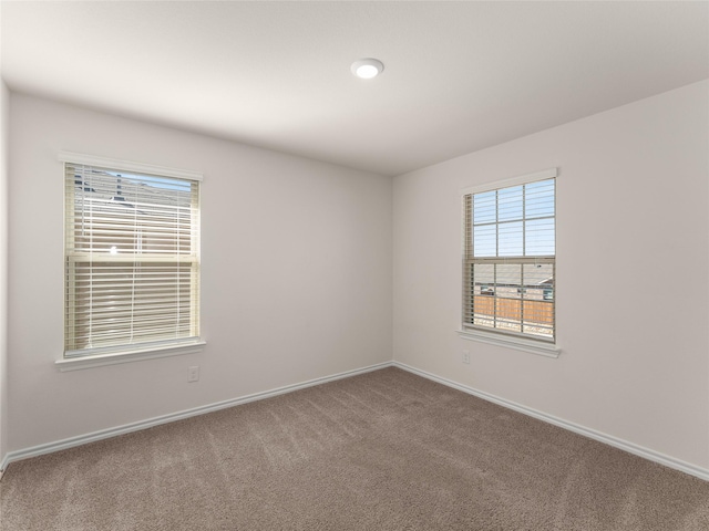 carpeted spare room with baseboards