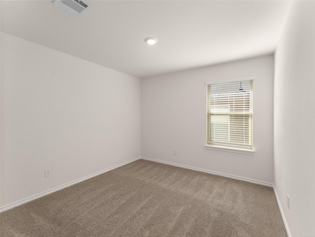 carpeted spare room with baseboards and visible vents