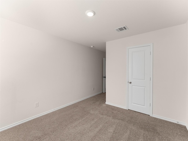 spare room featuring carpet floors, baseboards, and visible vents