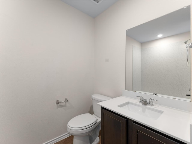 bathroom featuring vanity, baseboards, toilet, and wood finished floors