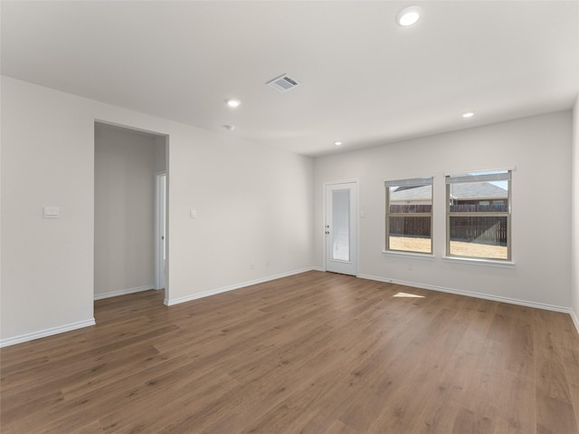 spare room featuring recessed lighting, baseboards, visible vents, and wood finished floors
