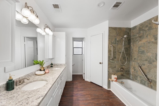 bathroom featuring tiled shower / bath combo, wood-type flooring, and vanity