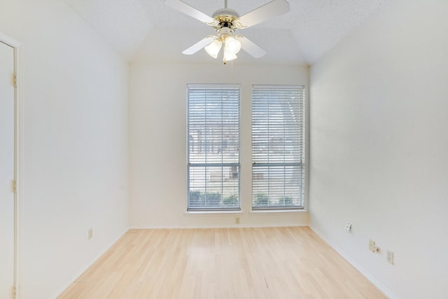 spare room with lofted ceiling, ceiling fan, a textured ceiling, and light wood-type flooring