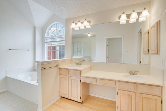 bathroom featuring lofted ceiling, vanity, wood-type flooring, a textured ceiling, and separate shower and tub